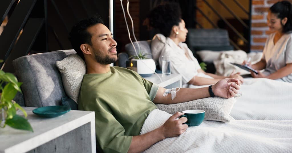 Clients relaxing during IV infusions in a modern brick-and-plant wellness studio